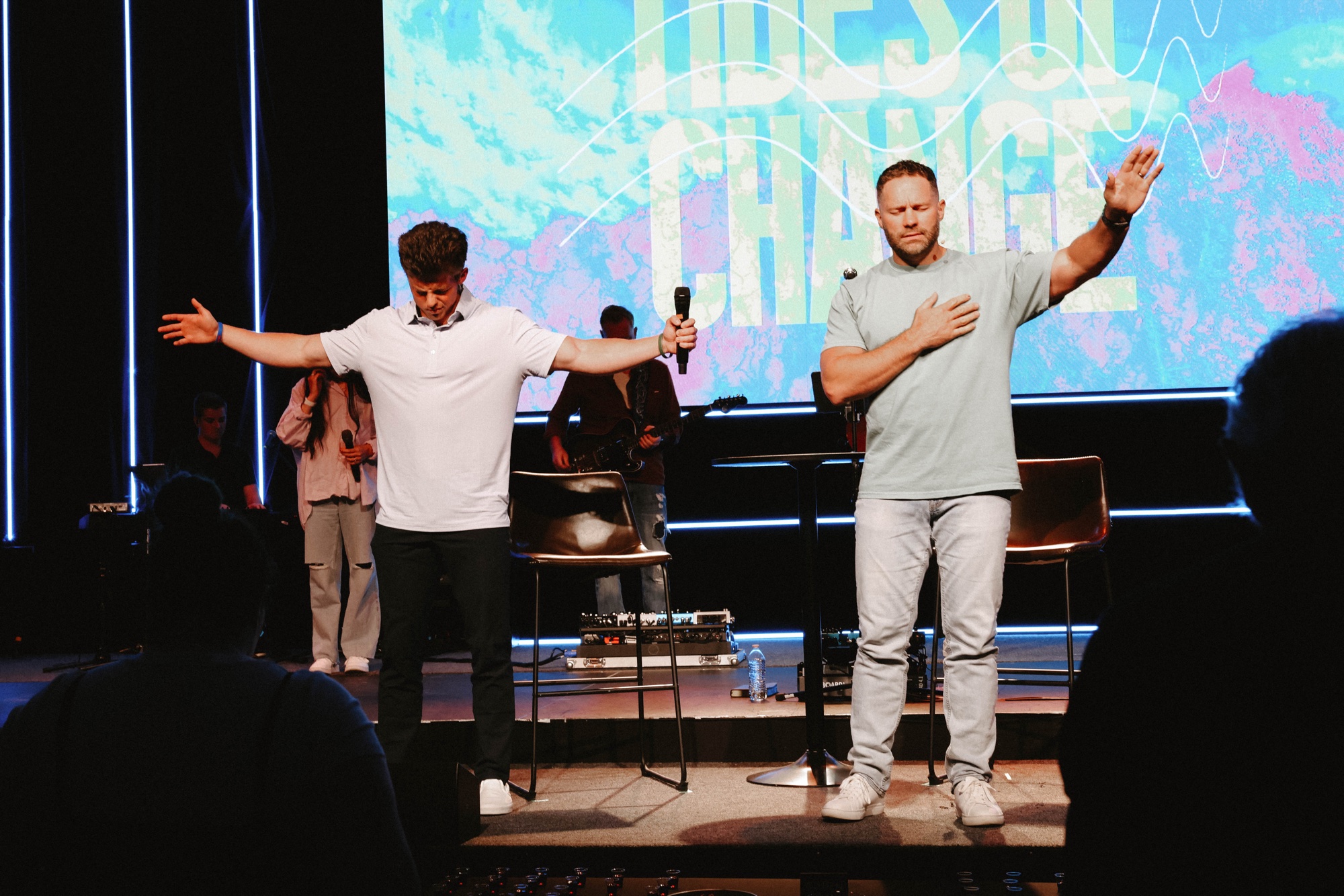Dylan ministering on stage with arms raised in worship