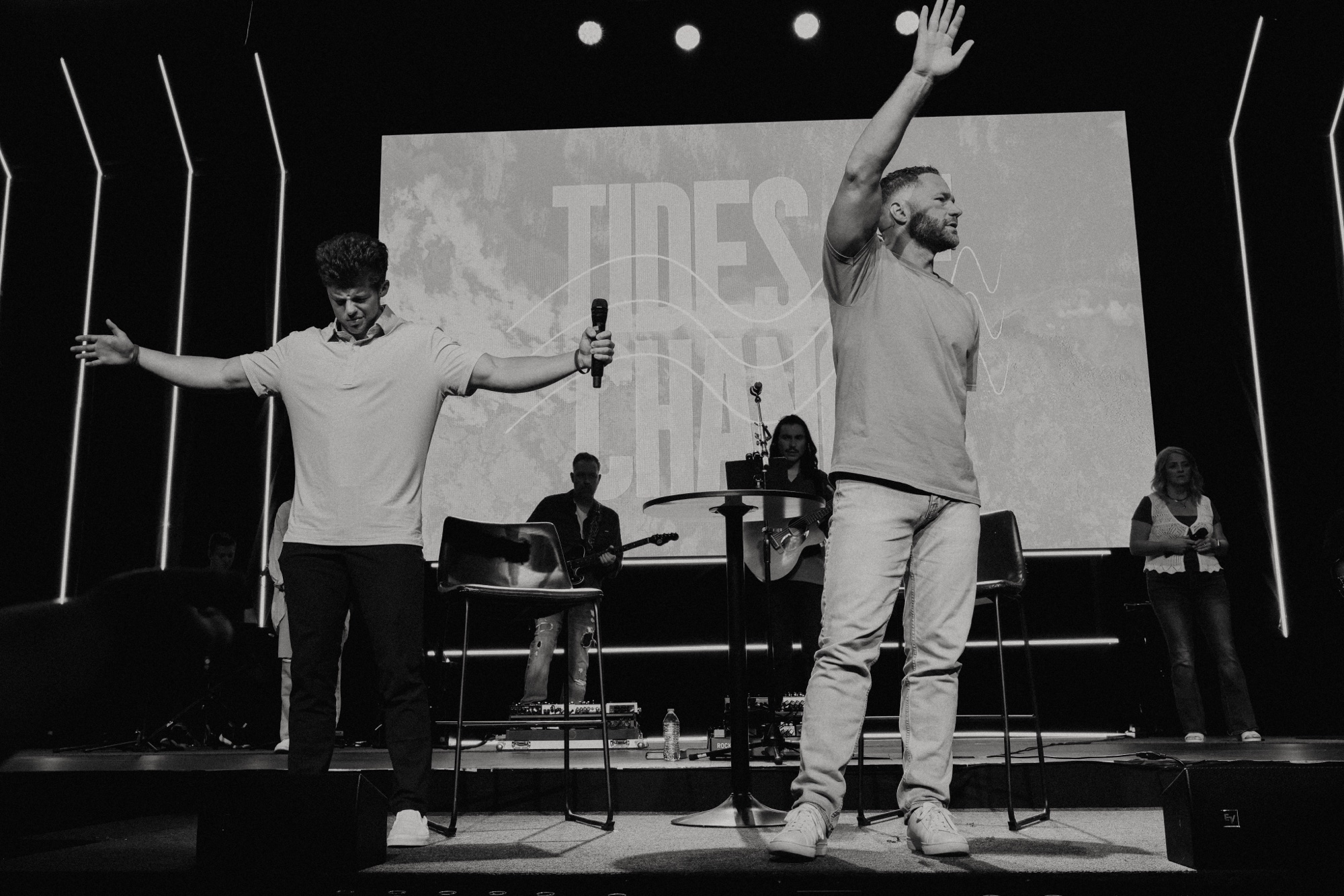 Dylan and a fellow minister on stage at Tides of Change, in black and white
